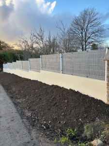 Photo de galerie - Création d’un muret (enduit ton pierre) avec une clôture en panneaux rigides (toile occultante grise)