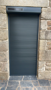 Photo de galerie - Pose d’un volet roulant solaire gris anthracite avec finition joint de ciment pierre auteur des coulisses du volet roulant 