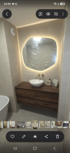 Photo de galerie - Pose d’un meuble vasque avec robinetterie encastrée, miroir lumineux et carrelage mural, avec finitions soignées.