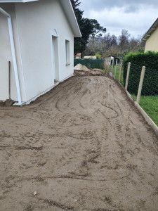 Photo de galerie - Décaissage, pose plaque sousbassement béton en clôture(sur la droite de la photo), mise en place remblais concassé béton, et finition a la dameuse 