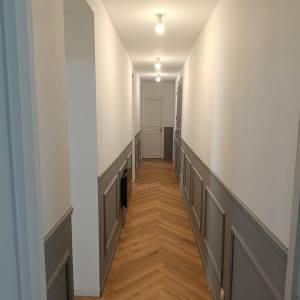 Photo de galerie - Pose d’un parquet en chevrons et réalisation de soubassements décoratifs.
