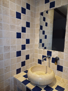 Photo de galerie - Création d'un espace travertin pour le plan vasque et mur avec robinetterie et miroir encastré.   Pose d'une vasque en pierre .