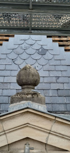 Photo de galerie - Rénovation de toiture en ardoises naturelles avec motif décoratif en écailles. Chaque ardoise est posée avec précision afin d'assurer une toiture élégante, étanche et durable.
