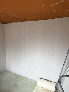 Photo de galerie - Pose de plaques de plâtre (placo) sur ossature métallique pour l’aménagement d’une pièce. Installation soignée, prête pour les bandes et la finition peinture.
