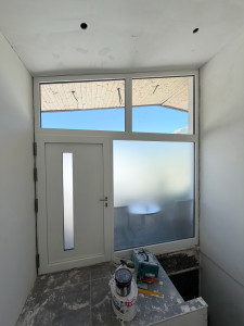 Photo de galerie - Pose d’une porte d’entrée PVC avec vitrages fixes.