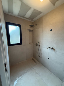 Photo de galerie - Réalisation d’une pose complet sol et mur en faïence 1.00x1.00 avec une niche avec des découpes à 45 degrés 