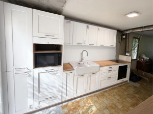 Photo de galerie - La cuisine de SoCoo’c. Des façades blanches, des touches bois et un esprit chaleureux