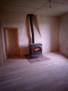 Photo de galerie - Pose parquet chêne sur lambourdes 
Mise en place d'une dalle béton ferraillée avec carrelage pour reprise du poêle à bois
Enduit chaux chanvre et création d'une niche en contre-plaqué peuplier au sein du mur, pour une bibliothèque, avec cadre en douglas.