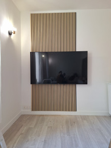 Photo de galerie - Pose de panneaux décoratif tasseaux en bois avec suspension Tv.