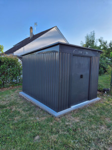 Photo de galerie - Réalisation d’une dalle en béton puis montage d’un abri de jardin métallique.
