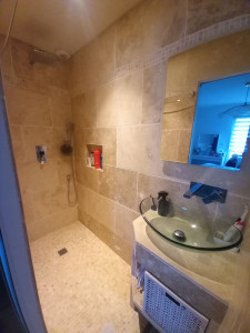 Photo de galerie - Réalisation d'une douche italienne en travertin.