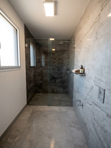 Photo de galerie - Réalisation d'une salle de bain en carrelage 30x60 cm effet marbre. Pose soignée pour une douche à l’italienne moderne, élégante et lumineuse.