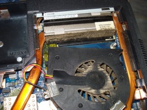 Photo de galerie - Problème semblable à la photo suivante mais sur celle-ci sur un ordinateur portable. On voit bien l'accumulation de poussière situé entre le ventilateur en noir et le radiateur en gris. L'air propulsé par le ventilateur n'atteint donc plus le radiateur.