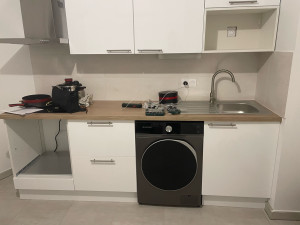 Photo de galerie - Installation de machine à laver avec raccordement à l’eau, à l’évacuation et à l’électricité, réglage de la stabilité et test de fonctionnement.