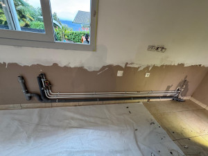 Photo de galerie - Création d’un réseau d’alimentation et d’évacuation d’eau avec pose et alignement des tuyauteries. Installation propre et prête pour raccordement des équipements sanitaires. 