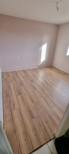 Photo de galerie - Pose de parquet stratifié pièces d'environ 13m2 avec isolation acoustique, plaintes et baquette de seuil de porte pas visible sur la photo.