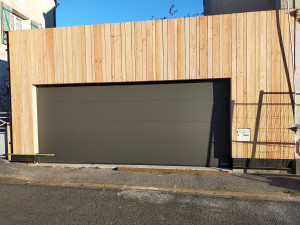 Photo de galerie - Pose de bardage douglas et d'une porte de garage sectionnelle motorisée. 