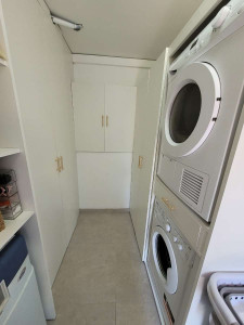 Photo de galerie - Création d'un cellier sur mesure complet avec aménagement de machine à laver avec rangements et porte pour balon avec un porte manteau 