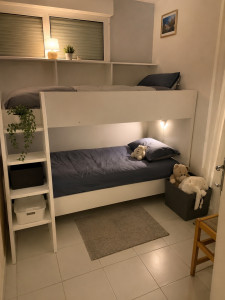 Photo de galerie - A ménagement d'un lit superposé blanc sur mesure avec rangements intégrés et échelle latérale. Idéal pour optimiser l'espace dans une chambre d'enfants, combinant confort, sécurité et étagères de rangement pratiques