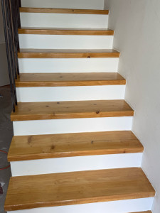 Photo de galerie - Rénovation complète d'un escalier encrassé par les graisses et l'usure. Après un dégraissage et ponçage intensif, le bois retrouve tout son éclat. Résultat : un aspect moderne et propre avec une finition vernie et blanche.
