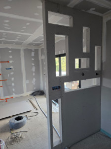 Photo de galerie - Travaux complets en plaques de plâtre, incluant l’isolation, la pose de cloisons et de petites décorations pouvant également servir de meubles fonctionnels.