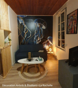 Photo de galerie - Pose d'une tapisserie panoramique dans ce salon, soigneusement choisie pour s'harmoniser avec le mobilier existant. Un résultat sur-mesure qui transforme totalement l'ambiance de la pièce !