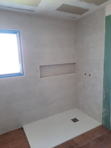 Photo de galerie - Pose de faïence 30x90  avec une petite niche pour ranger les produits 