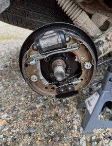 Photo de galerie - Démontage et intervention sur un mécanisme de frein à tambour. Travail de maintenance mécanique et contrôle des éléments du système de freinage.