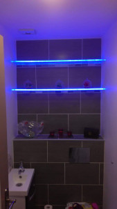 Photo de galerie - Création d'un caisson pour pose d'un WC suspendu, avec pose du carrelage du mur et création de deux étagères en plexiglas avec rétroéclairage LED bleu...
