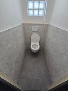Photo de galerie - Pose de toilettes suspendues avec habillage en carrelage sol et murs.