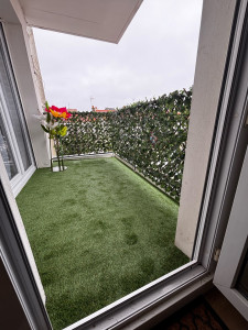 Photo de galerie - Découpe et pose de gazon synthétique ainsi que du brise vu sur ce balcon 