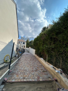 Photo de galerie - Allée en pavés réalisée entre une habitation et une clôture végétale