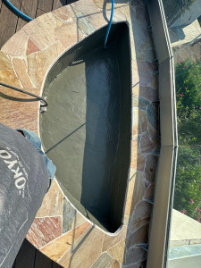 Photo de galerie - Réalisation d'une jardinière maçonnée en toiture terrasse avec double étanchéité liquide au fond, arrosage auto, évacuation des eaux, et margelle en opus de brazilia rose maçonnée. 