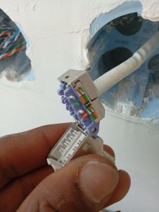 Photo de galerie - Installation et raccordement de prises RJ45 pour réseaux informatiques et Internet. Câblage et connexions réalisés avec soin pour assurer une transmission de données fiable et rapide.