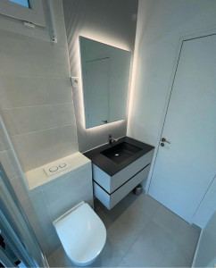 Photo de galerie - Réalisation d’une salle de bain contemporaine : pose d’un meuble vasque suspendu, miroir LED, WC suspendu, robinetterie, habillage mural et finitions soignées. Un résultat moderne, pratique et élégant.