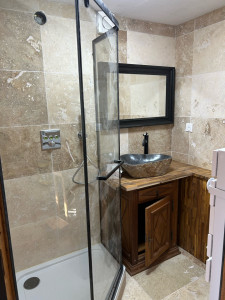 Photo de galerie - Réalisation complète d’une salle de bain avec carrelage toute hauteur en travertin naturel 