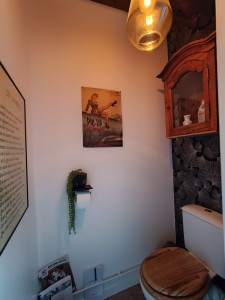 Photo de galerie - Revêtements mural chic avec une petite armoire en bois ancienne pour y ranger les produits ménagers et cuvette en bois je précise ? 