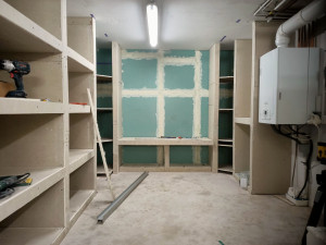 Photo de galerie - Aménagement intérieur d’un sous-sol avec pose de rangements et préparation des surfaces.