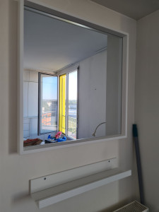 Photo de galerie - Pose d'une etagere et d'un miroir dans mur béton 