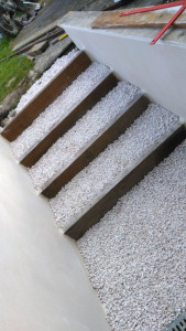 Photo de galerie - Création d'un escalier bois/galets montage muret et finition enduit 