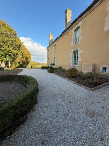 Photo de galerie - Réalisation d’une cour en gravier avec création de bordures pour délimiter les espaces et structurer les aménagements paysagers.