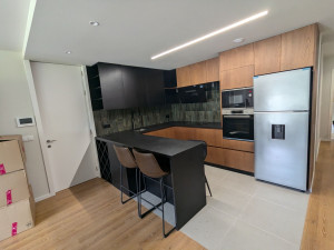 Photo de galerie - Conception et construction de Cuisine complète sur mesure, feuille naturelle de bois, laqué noir texturé et plan de travail en granit noir Zimbabwe finition anticato.