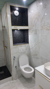 Photo de galerie - Rénovation complète d’une salle de bain avec reprise complète de la plomberie, pose du carrelage effet marbre, mosaïque, niches murales, espace douche et finitions haut de gamme.