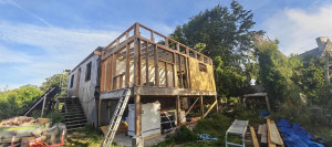 Photo de galerie - Construction d'une extension ossature bois sur bois sur pilotis, toit plat en epdm, isolation laine de bois et bardage bois.