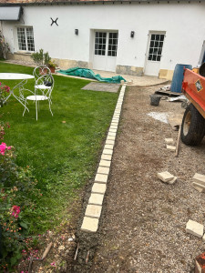 Photo de galerie - Pose de chaînette de pavés pour délimiter la pelouse et l’allée gravillonner 
