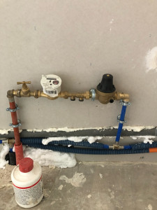 Photo de galerie - Installation et raccordement du réseau d’alimentation en eau – compteur, vannes et réducteur de pression. »