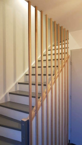 Photo de galerie - Création d’un claustra en bois sur mesure avec intégration discrète d’un placard sous escalier.