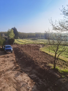 Photo de galerie - Arrachage de haie pour permettre de retrouver le talus, plantation d’arbres fruitiers et mise en place d’un couvre sol constitué de copeaux de bois issus de la haie arracher.

terrassement et réfection des talus à la pelleteuse 
