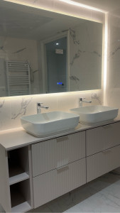Photo de galerie - Installation d’un meuble de salle de bain double vasque, pose du plan de travail, des vasques, de la robinetterie et du miroir LED.