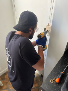 Photo de galerie - Ouverture et remplacement de serrure Artisan qualifié en pleine intervention, équipé de matériel adapté et de protections de sécurité, pour garantir un travail précis, fiable et durable.